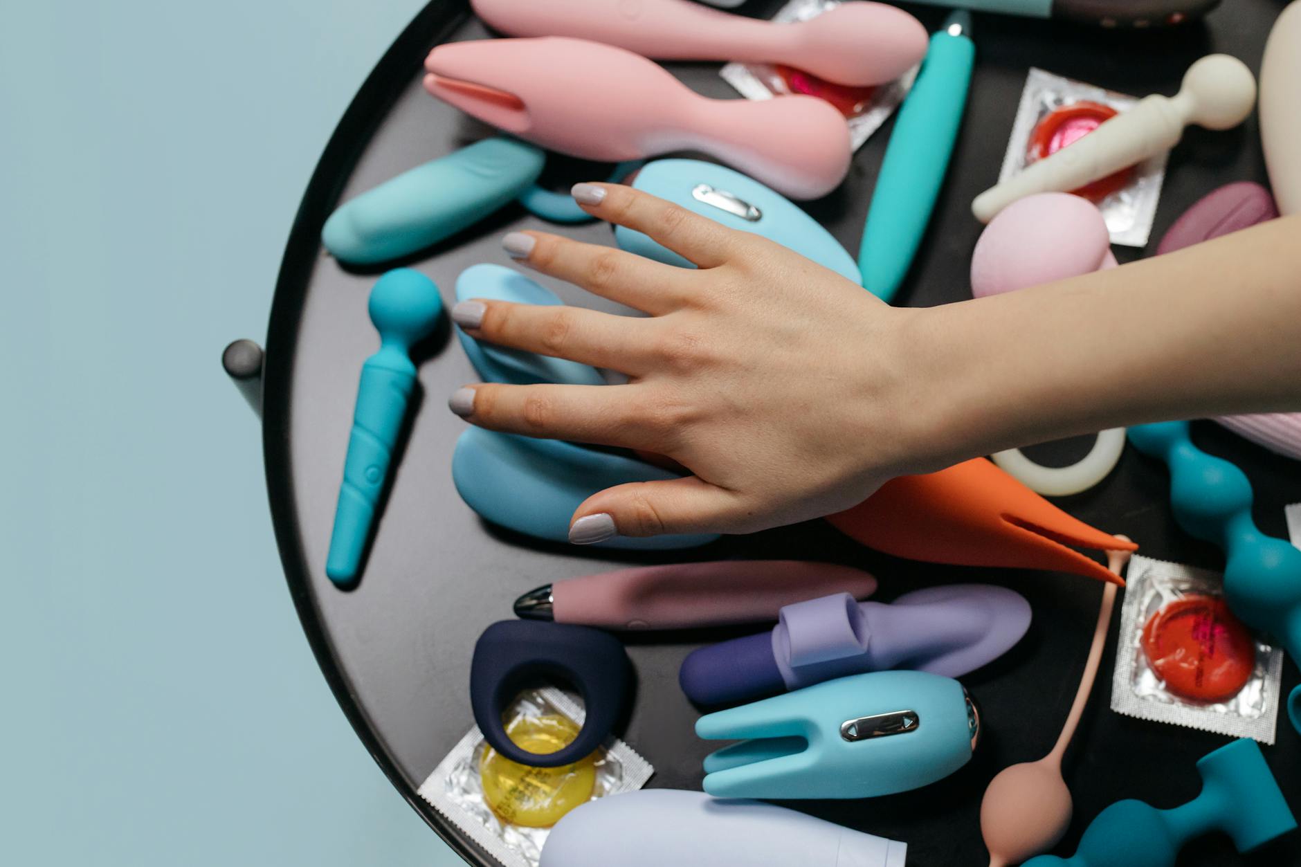 Hands holding a blue vibrator against a purple background