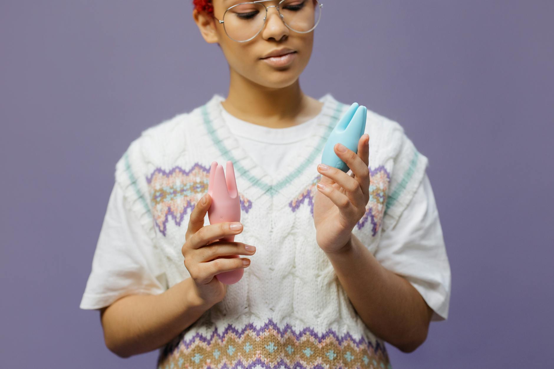 Woman holding colorful vibrators, considering pleasure options while managing medication side effects.