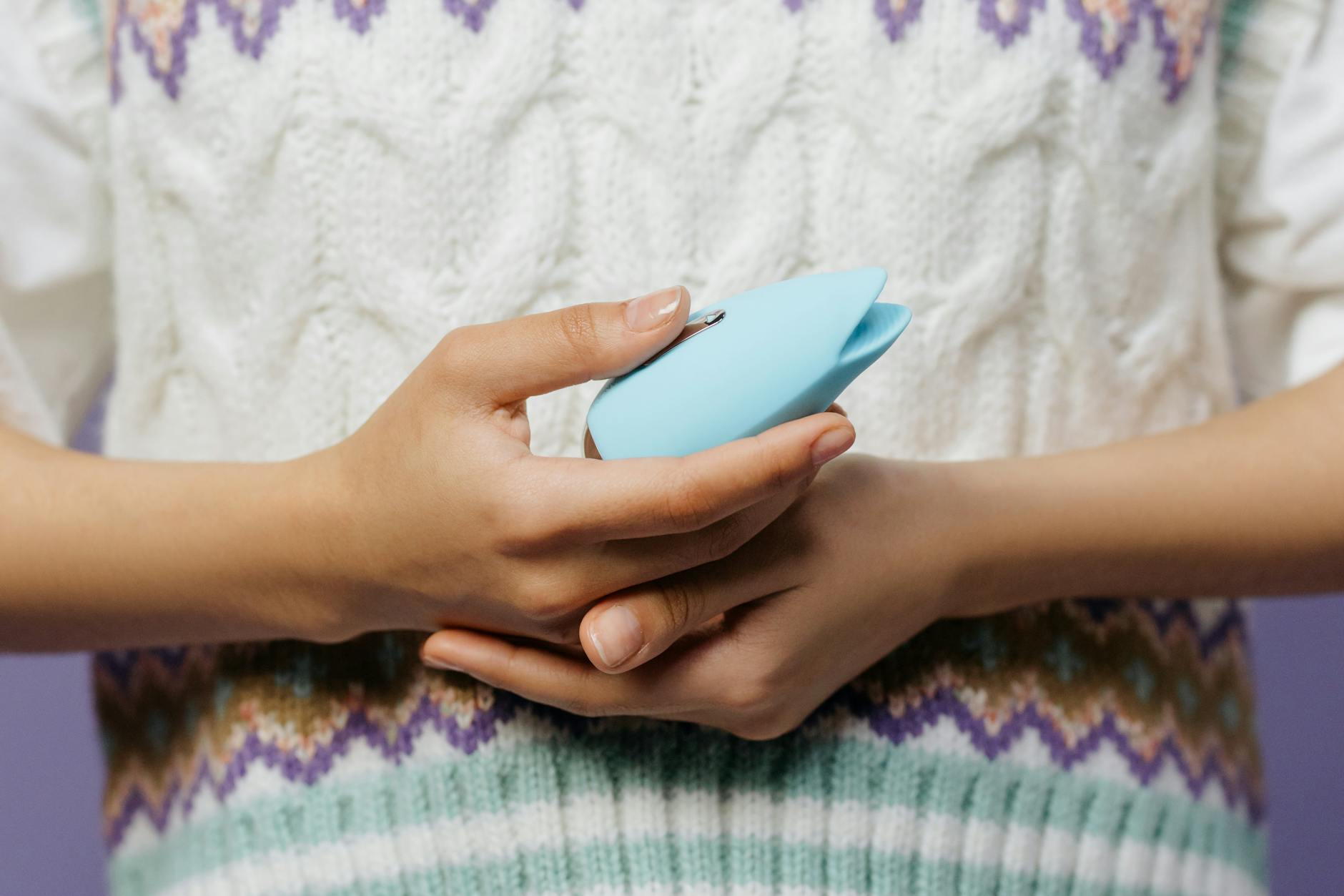 Close-up of hands holding a lemon clitoral vibrator together during intimate moment